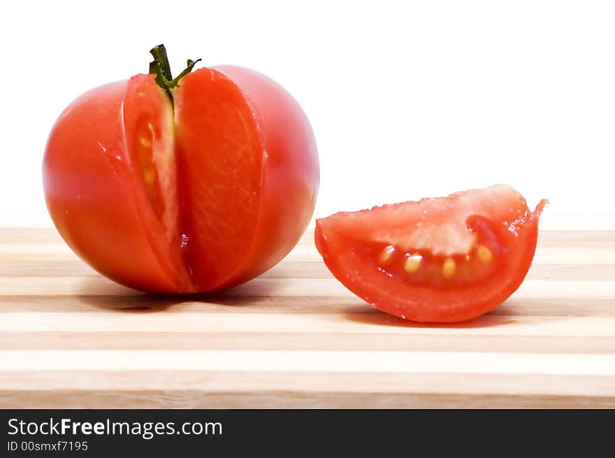 Juicy tomato on wooden plate