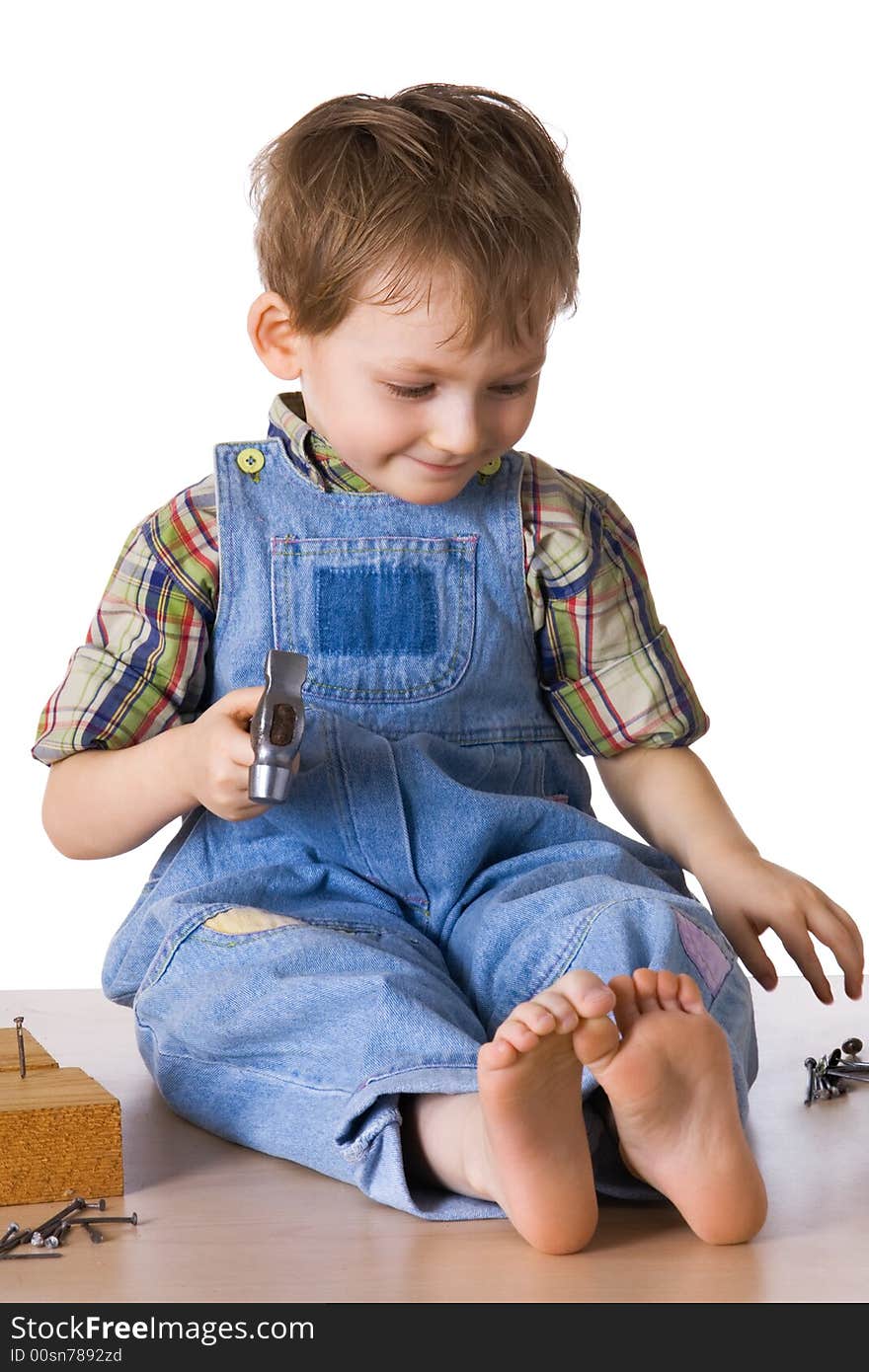 Kid hammers a hammer in nails