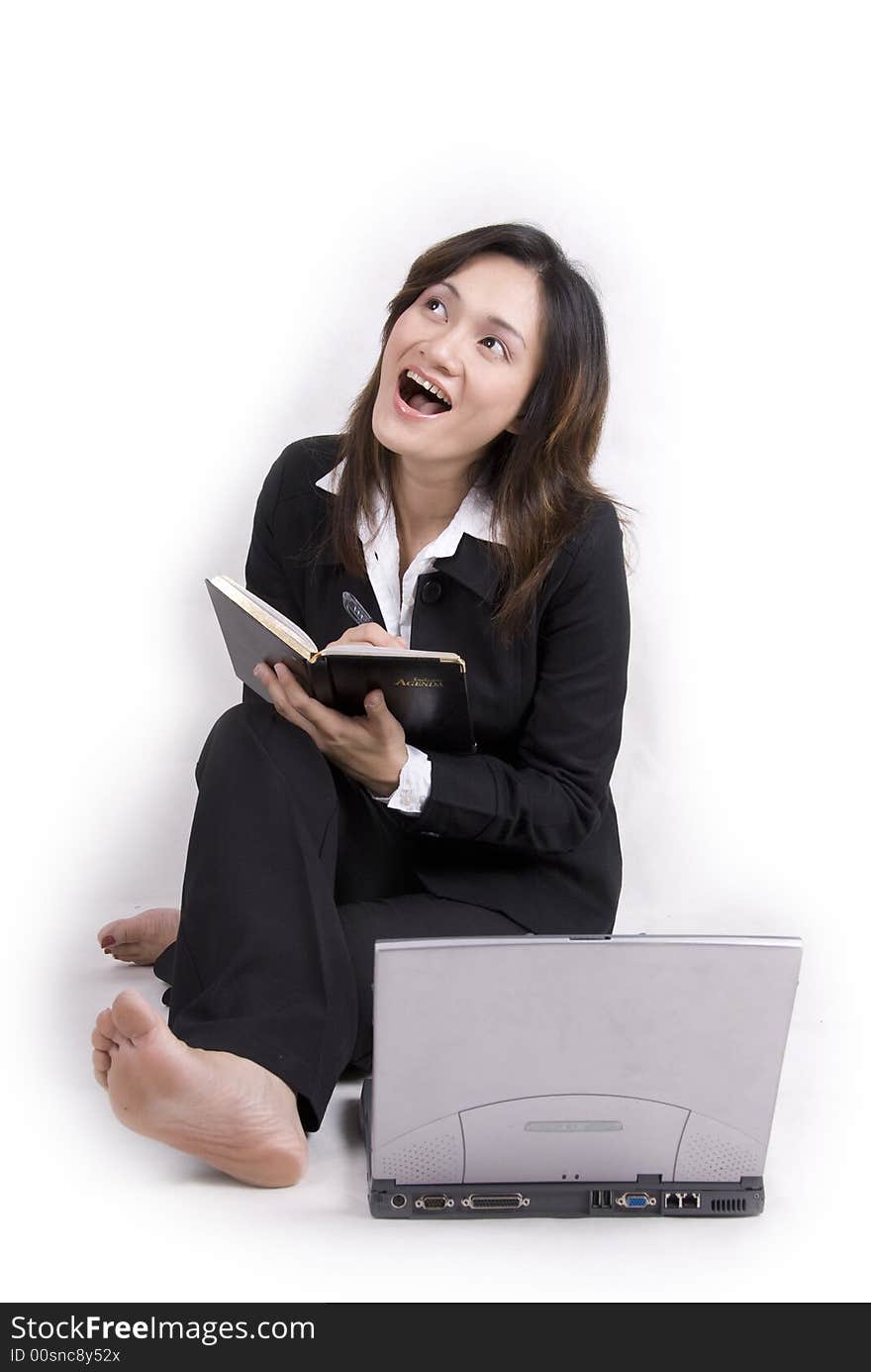 An Asian beautiful girl with confident with laptop and agenda book - isolated on white. An Asian beautiful girl with confident with laptop and agenda book - isolated on white