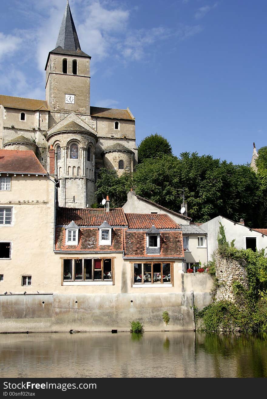 French Riverside Village with a Medieval Church and Buildings. French Riverside Village with a Medieval Church and Buildings