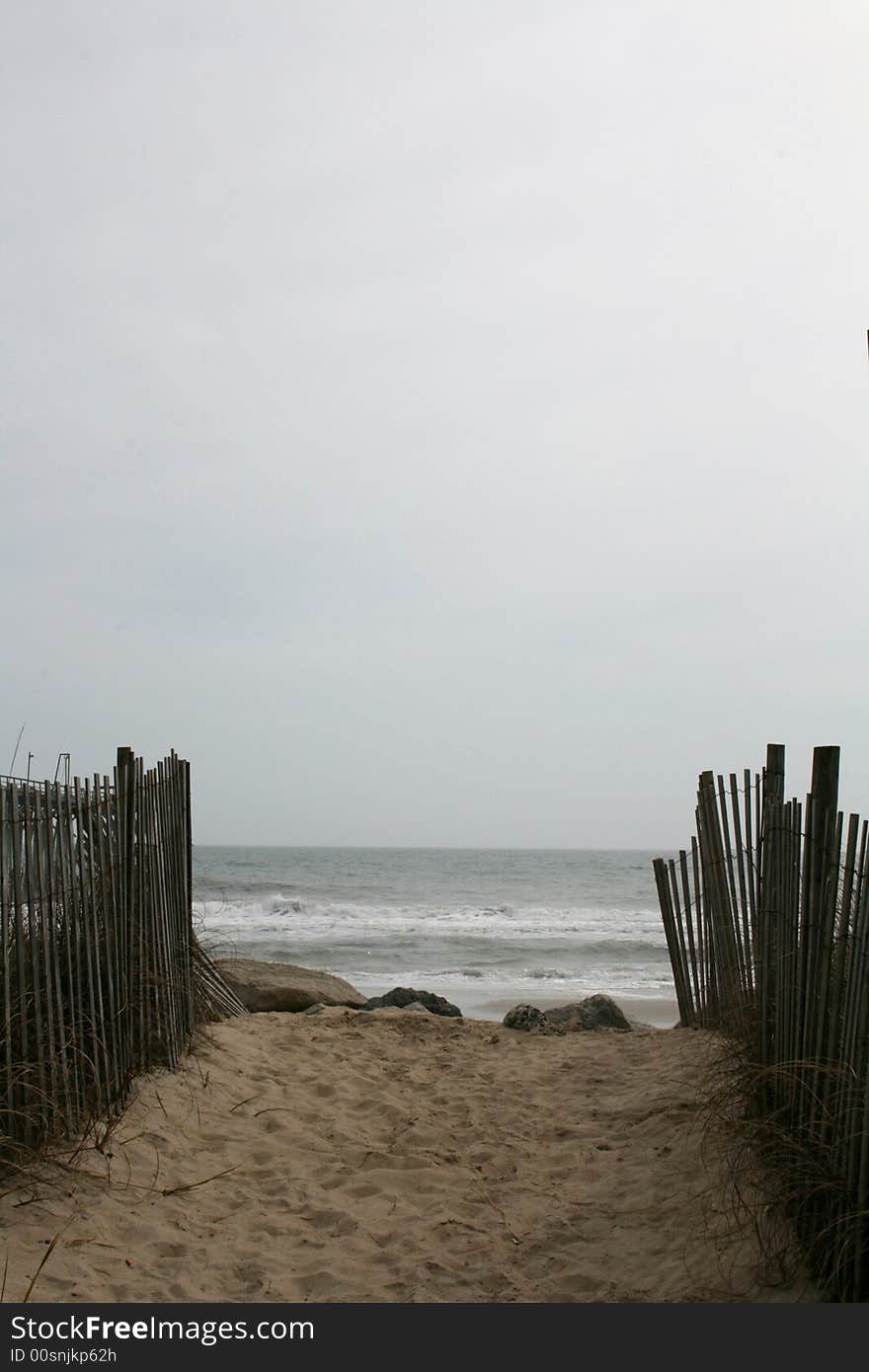 Sandy pathway to beach with fence to lead the way. Sandy pathway to beach with fence to lead the way.