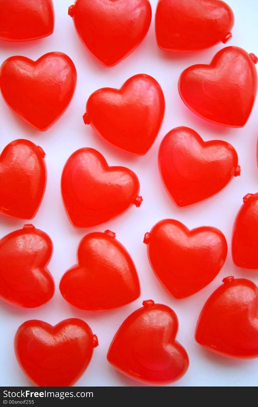 Red plastic love hearts on a white background