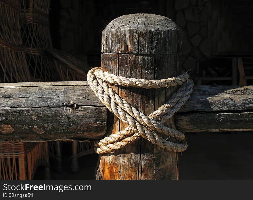 Wooden fence and rope on black background