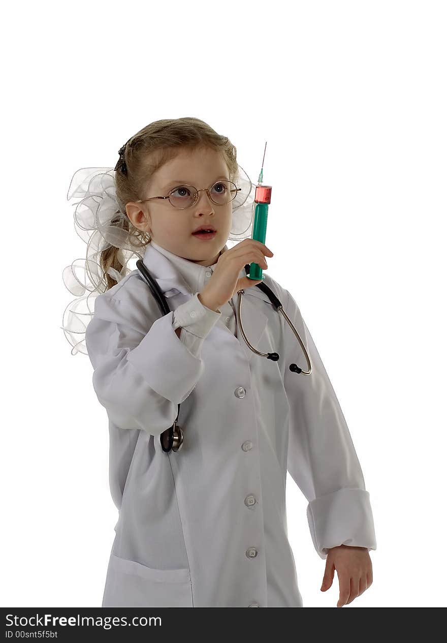 The girl plays with a syringe and a stethoscope and dreams to become the doctor. Isolated on white background. The girl plays with a syringe and a stethoscope and dreams to become the doctor. Isolated on white background.