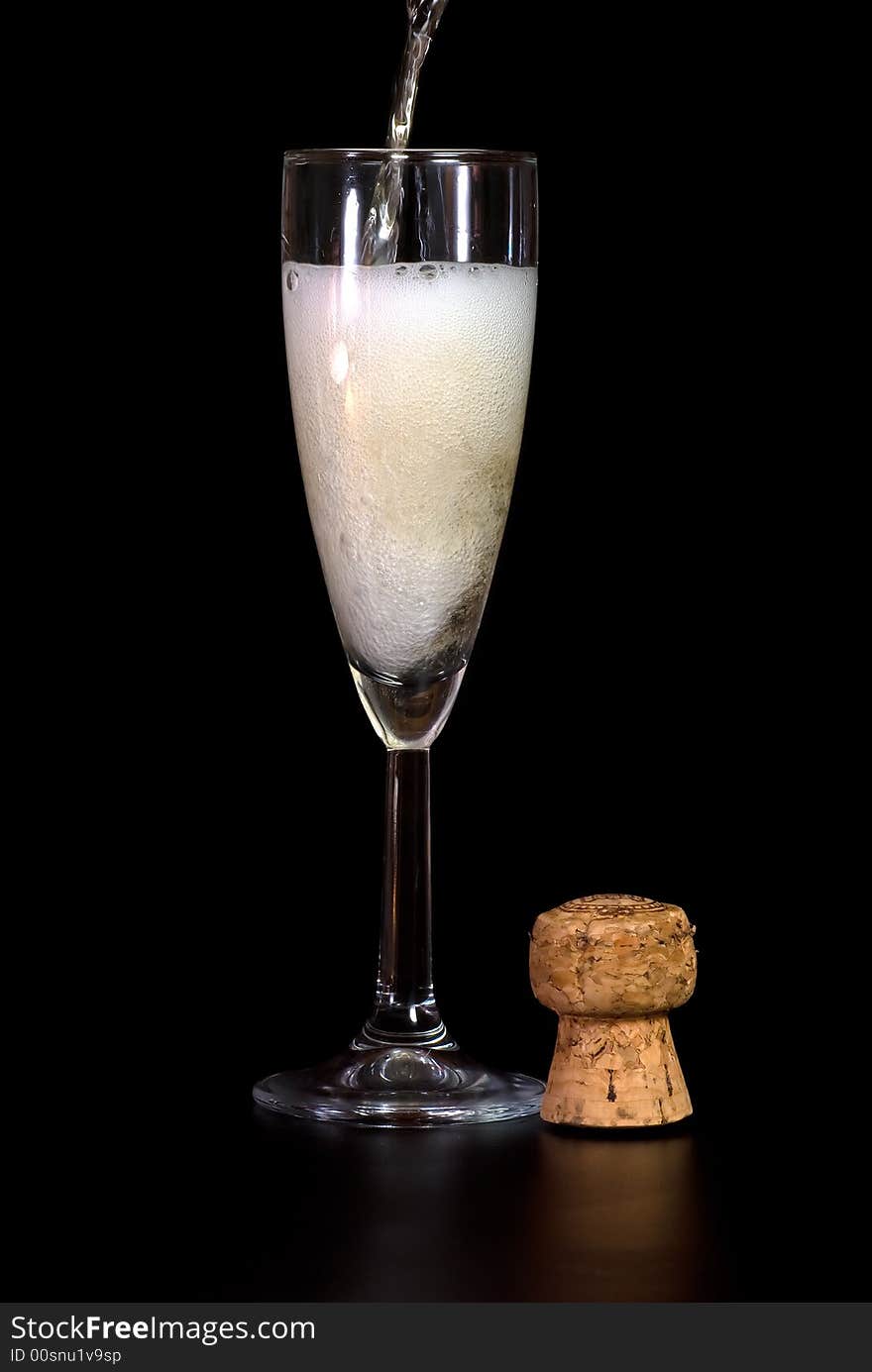 Champagne glass and a cork in black background. Champagne glass and a cork in black background.