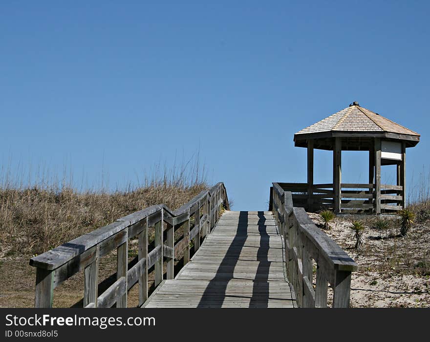 Wood walkway over dunes to beach and beach front gazebo. Wood walkway over dunes to beach and beach front gazebo.