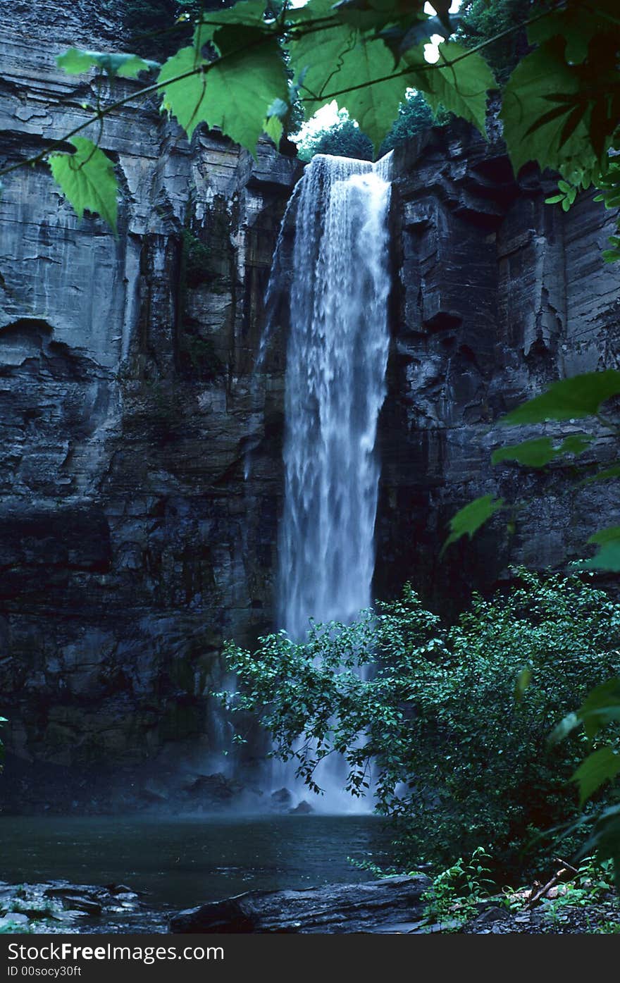 A large waterfall located at the bottom of a creek