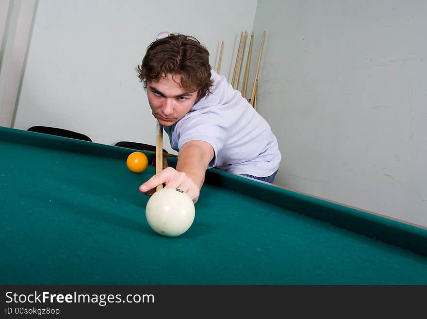 The yound guy plays billiards. The yound guy plays billiards