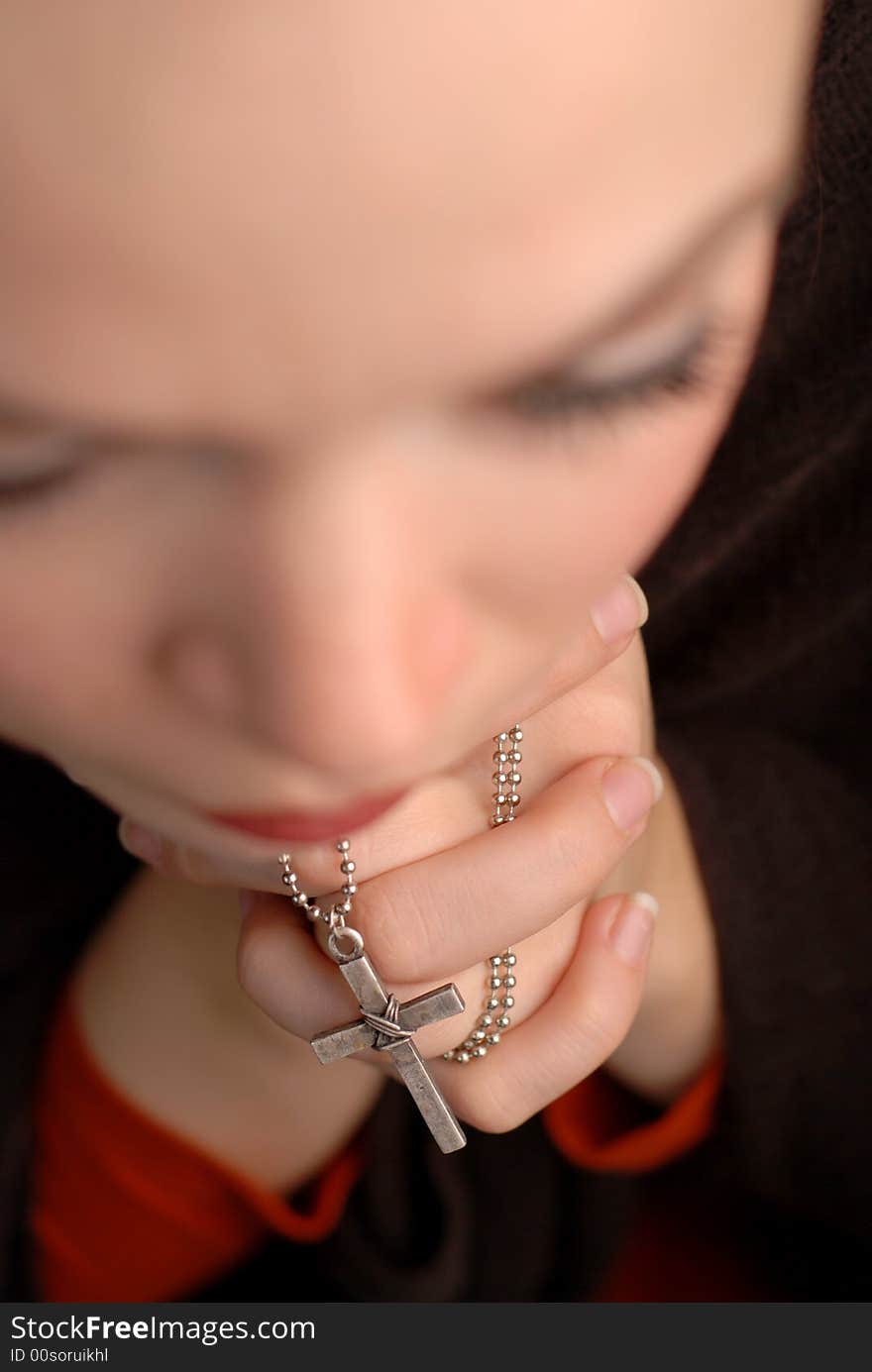 A woman is praying to god with hope(focus is on the cross). A woman is praying to god with hope(focus is on the cross)