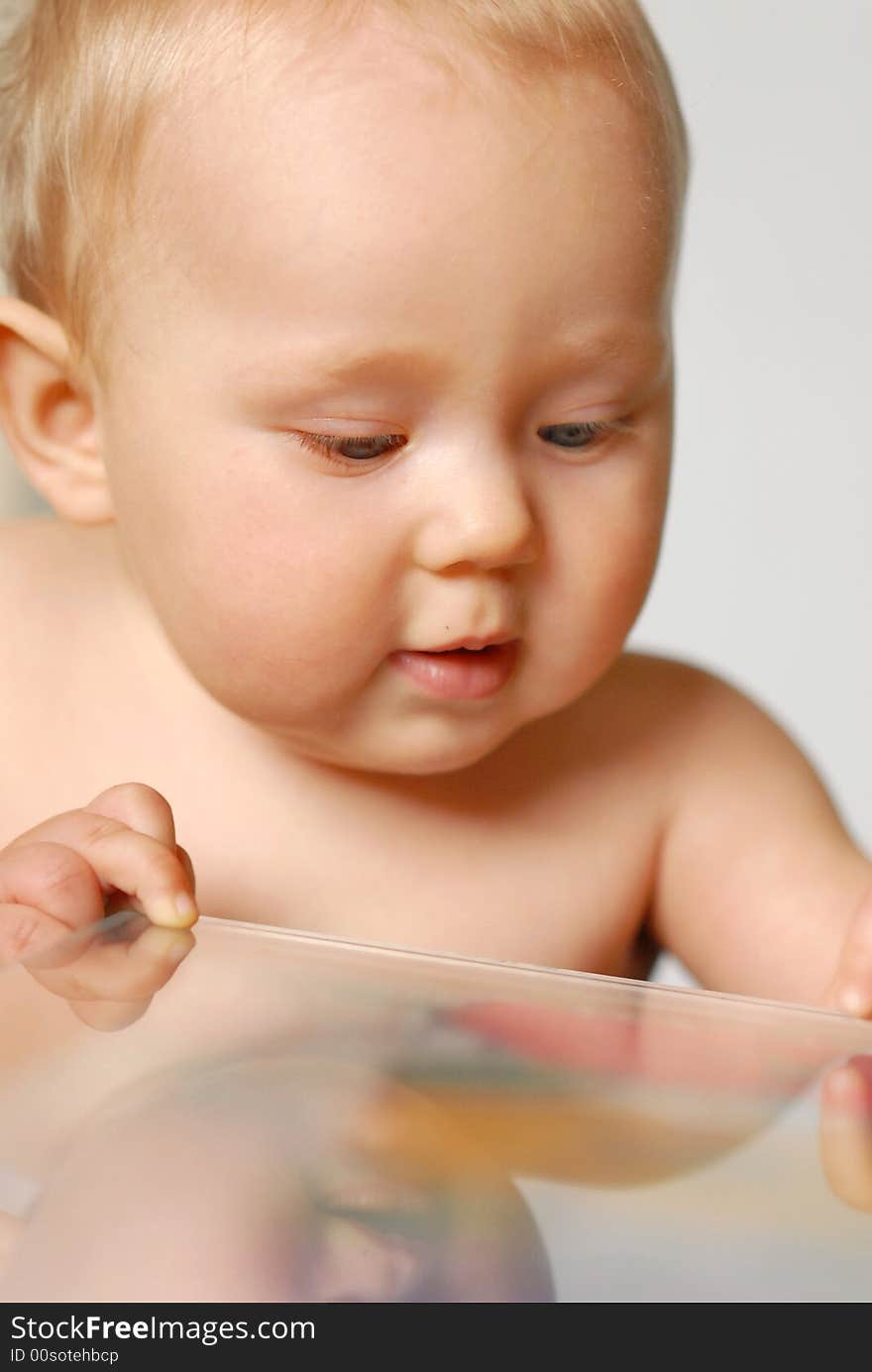 A baby standing next to a table