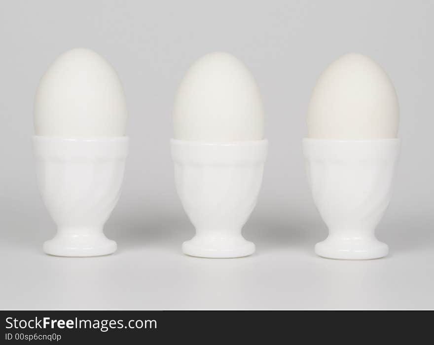 Three white eggs in eggcups