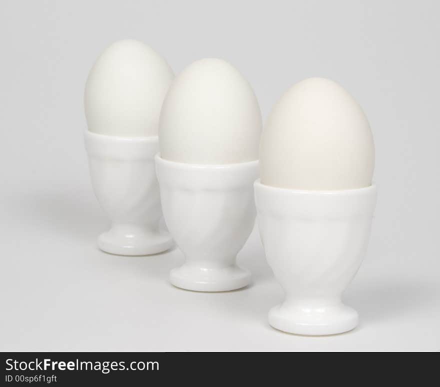 Three white eggs in eggcups