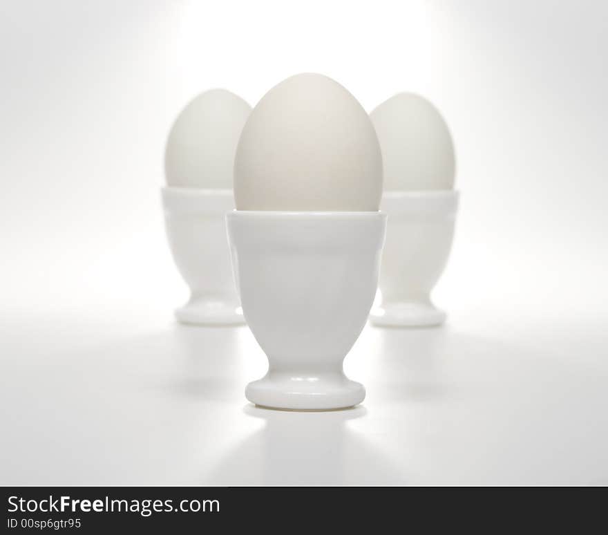 Three white eggs in eggcups