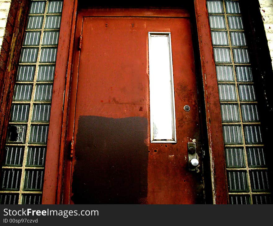 Dilapidated red door to an abandoned office building. Dilapidated red door to an abandoned office building