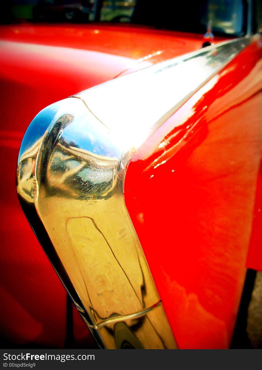 Close up of the chrome tail fin of a red vintage car