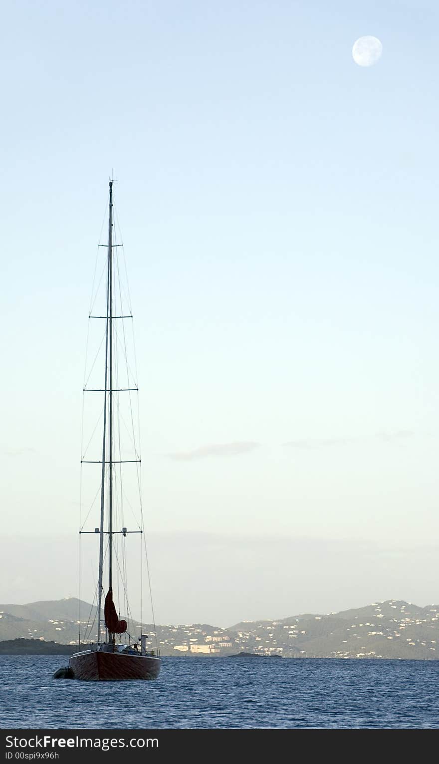 Sailboat at anchor with moon in background. Sailboat at anchor with moon in background.