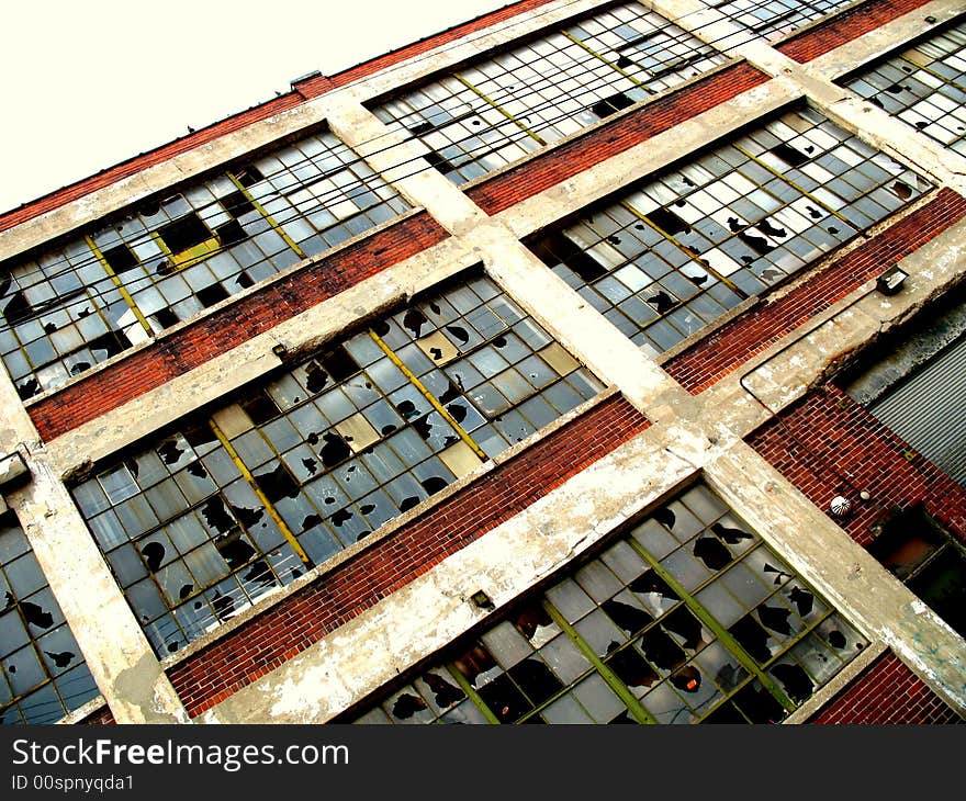 Broken windows framed by brick walls at an abandoned factory