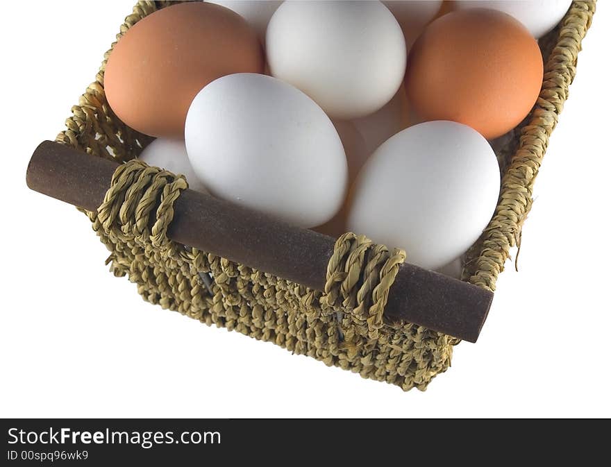 Isolated straw basket with brown and white eggs. Isolated straw basket with brown and white eggs.