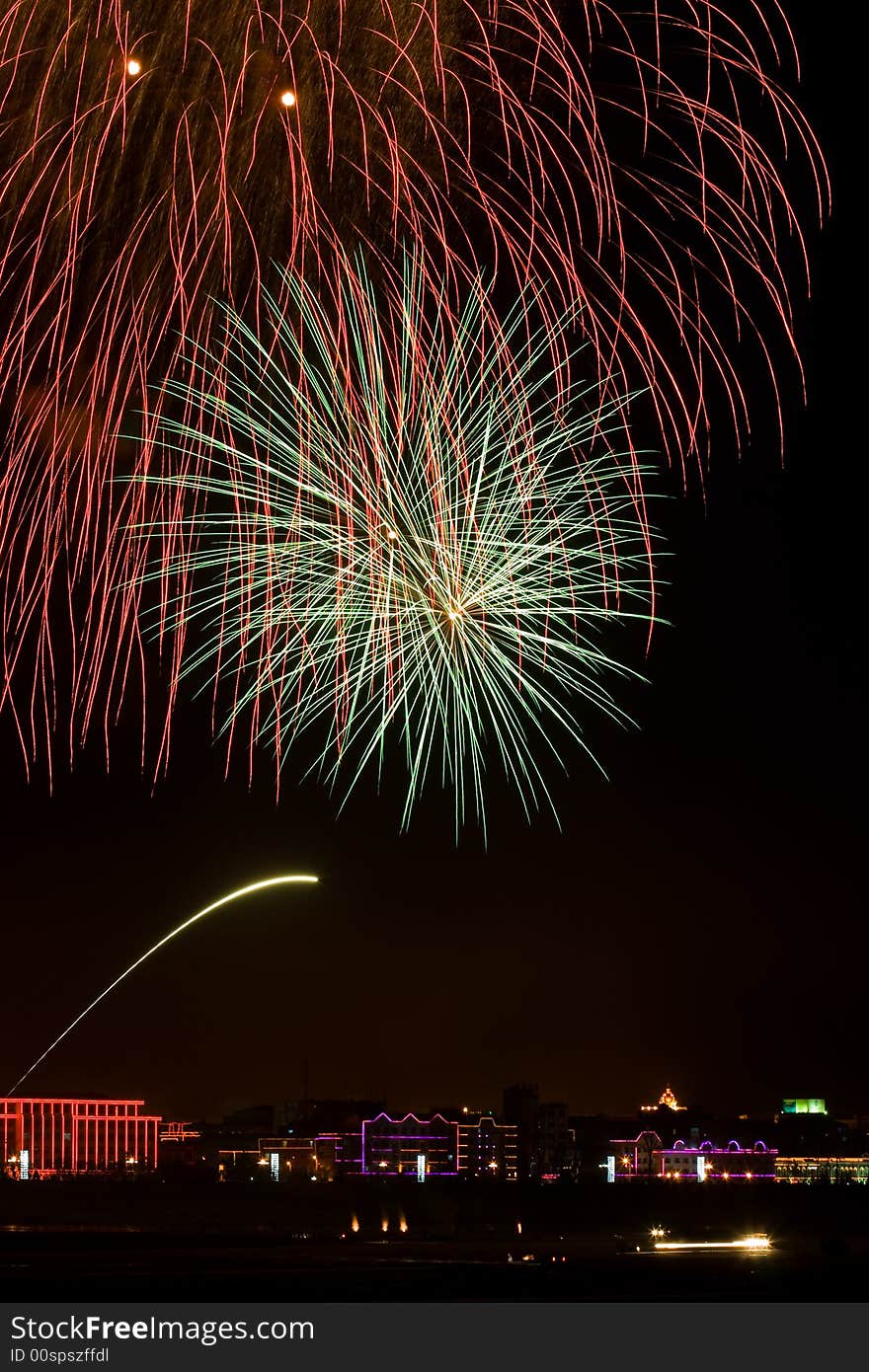 Blowing fire works over the buildings in the dark sky. Blowing fire works over the buildings in the dark sky