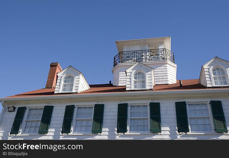 A large coastal home with red tiles and widows walk. A large coastal home with red tiles and widows walk