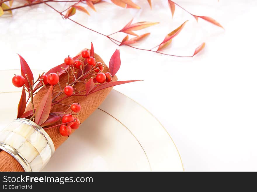 Decorative cloth napkin in napkin ring with red and orange leaves and berries. Decorative cloth napkin in napkin ring with red and orange leaves and berries