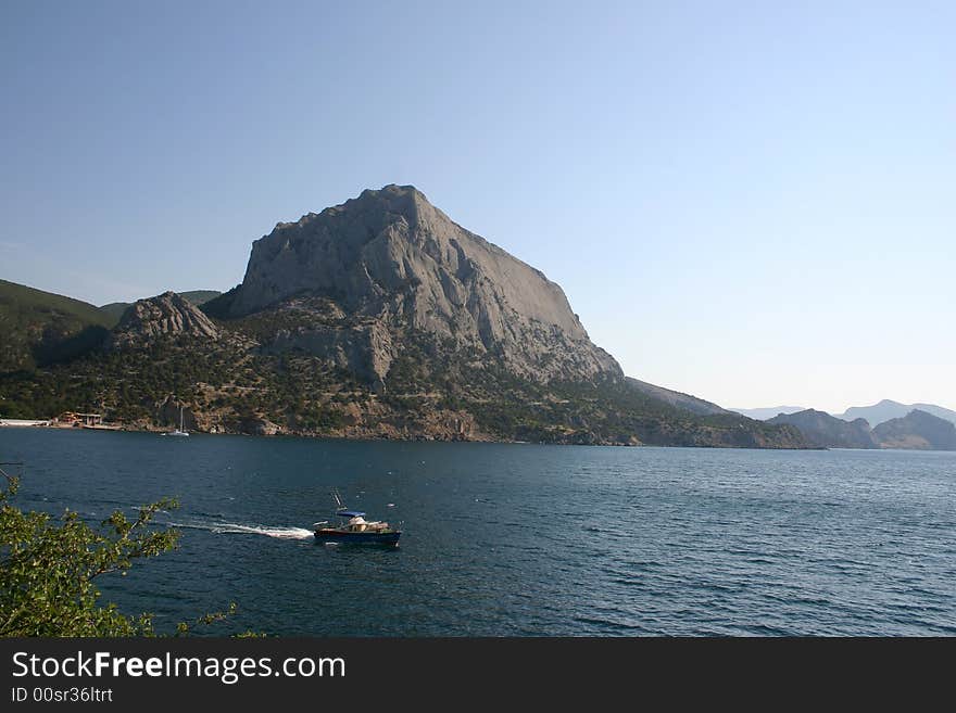 Sailboat sails seaborne, is seen part of coast