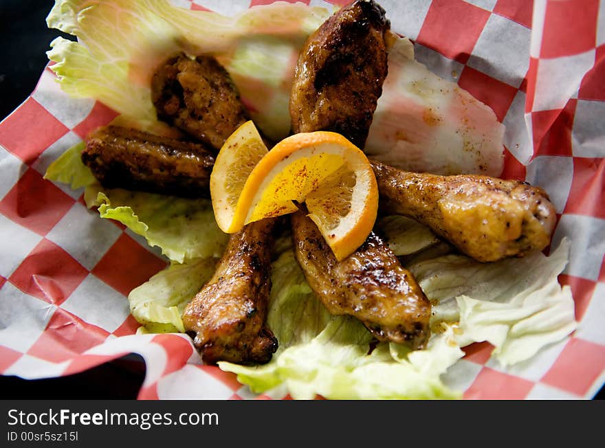 Image of baked chicken wings topped with lemon slice