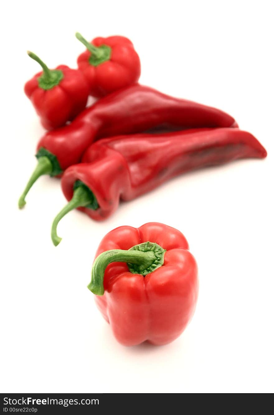 Different kinds of red peppers isolated on white.