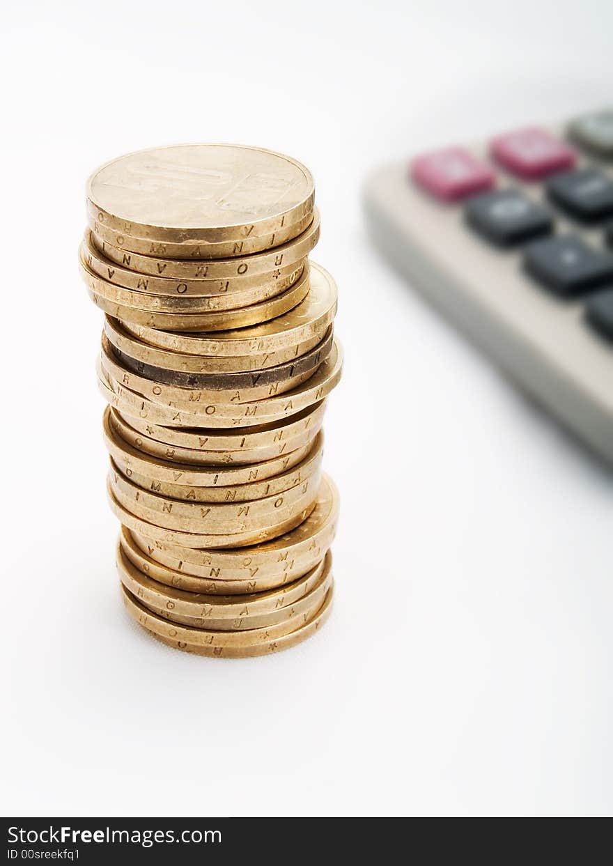 Pile of coins and calculator on a white background. Pile of coins and calculator on a white background