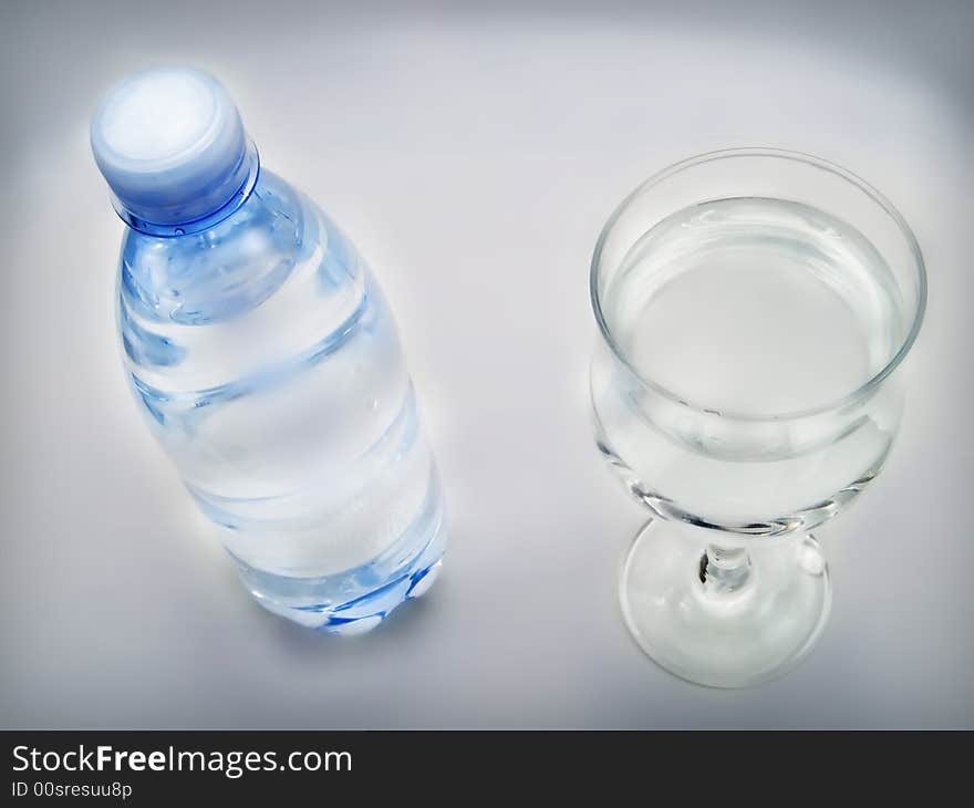 Bottle of water and glass on a white background