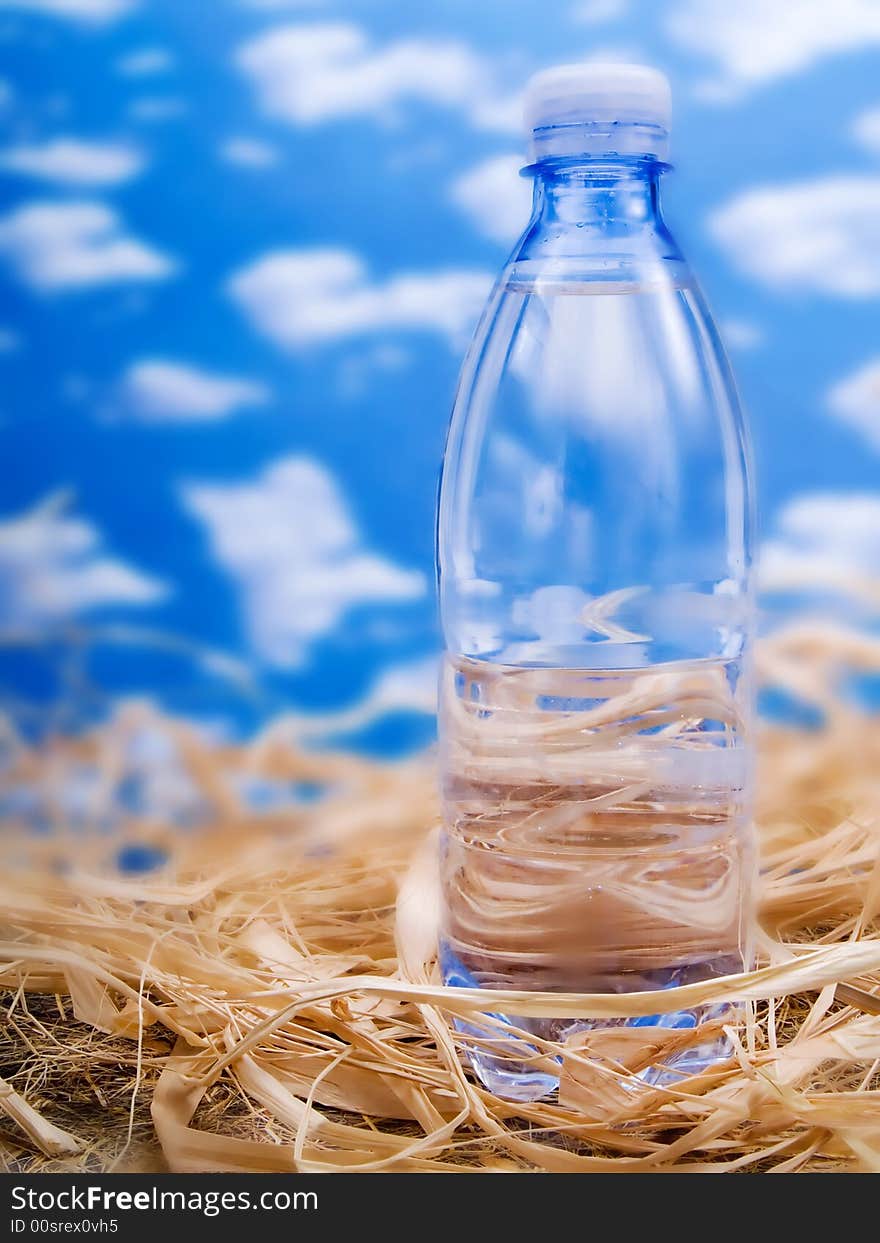 Bottle of mineral water over a blue sky. Bottle of mineral water over a blue sky