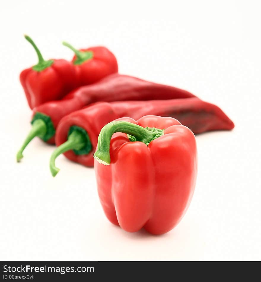 Different kinds of red peppers isolated on white.