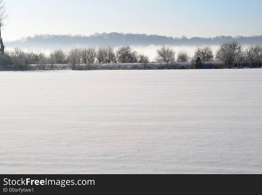 Frozen landscape with fog in distant hills