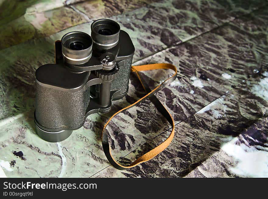 Black binoculars on photo map. Black binoculars on photo map