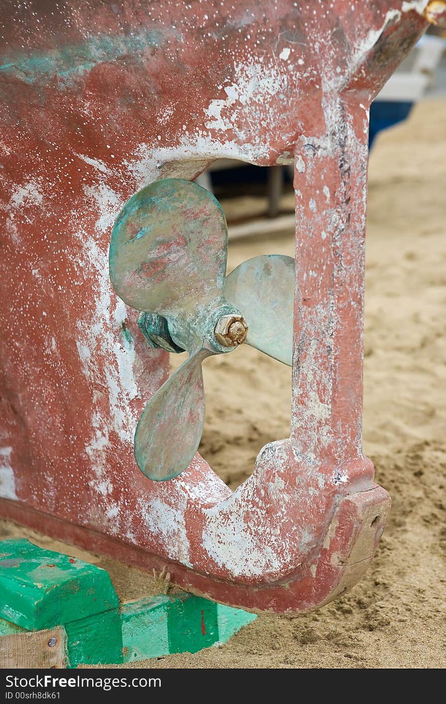 Old and grunge boat propeller in a sandy beach