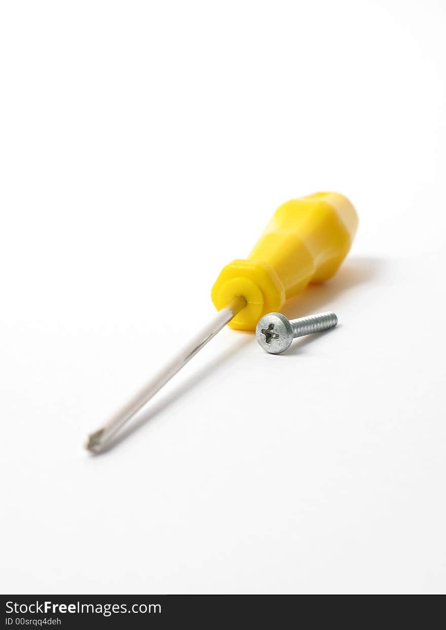 Yellow screwdriver with  silver screw in a white background