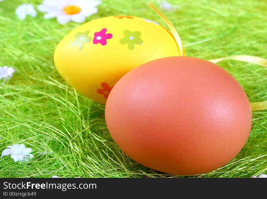 Pastel and colored Easter eggs on green