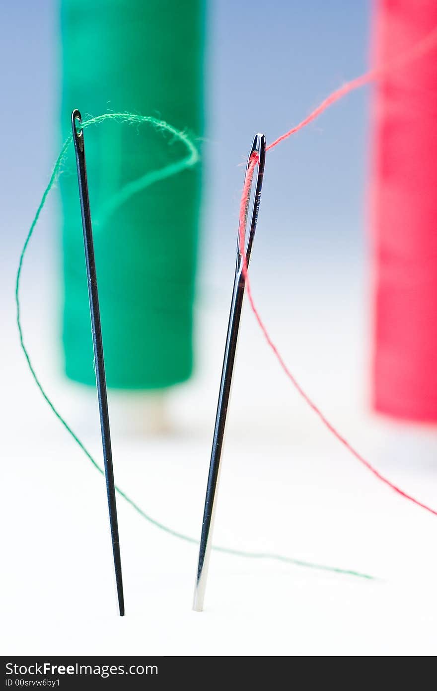 Macro shot of needles with the spools in the background. Macro shot of needles with the spools in the background