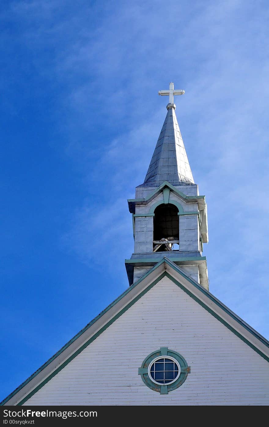 Church steeple against a blue sky, reflecting sunlight. Church steeple against a blue sky, reflecting sunlight