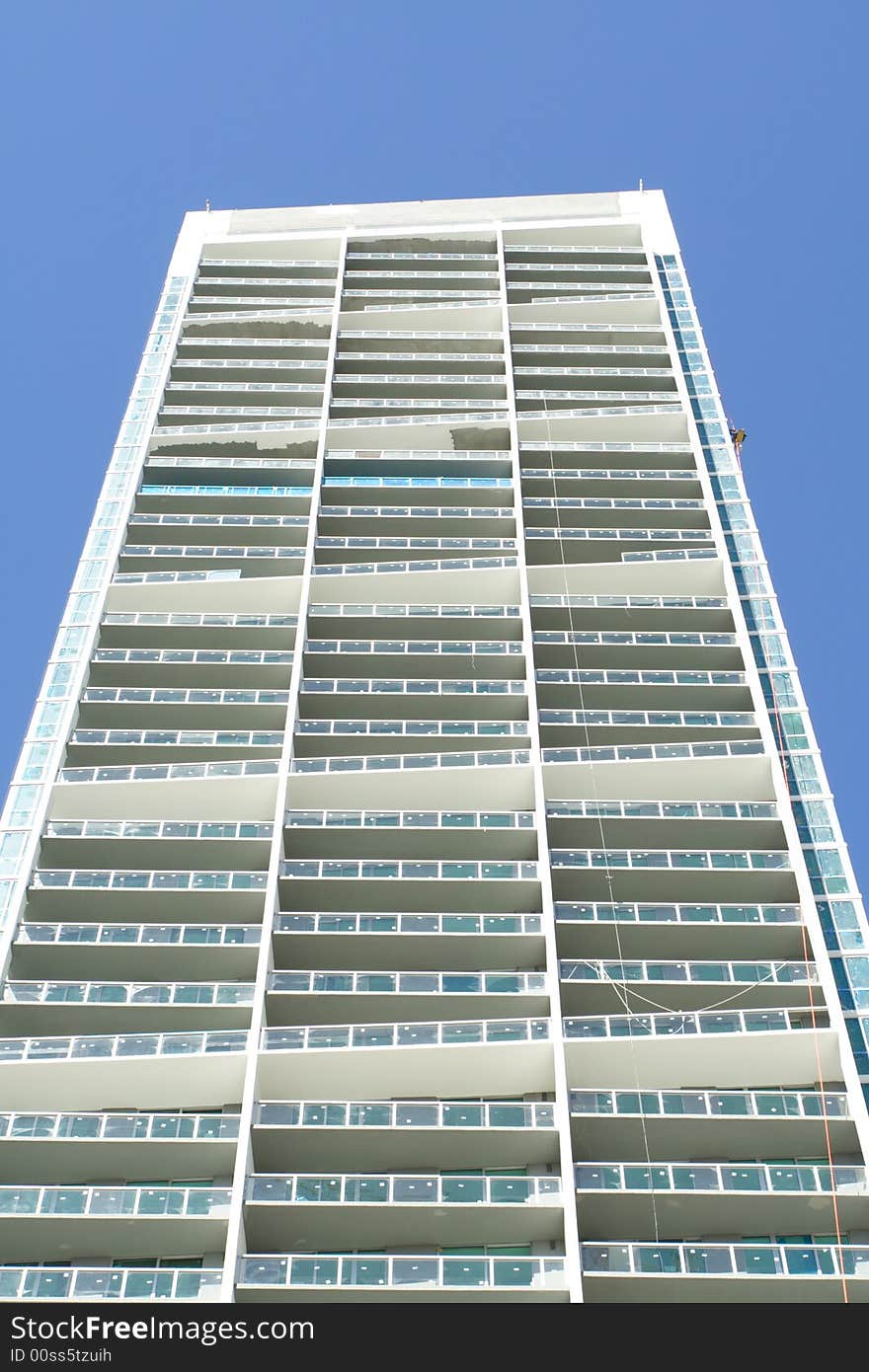 Modern abstract condominium building on a blue sky. Modern abstract condominium building on a blue sky