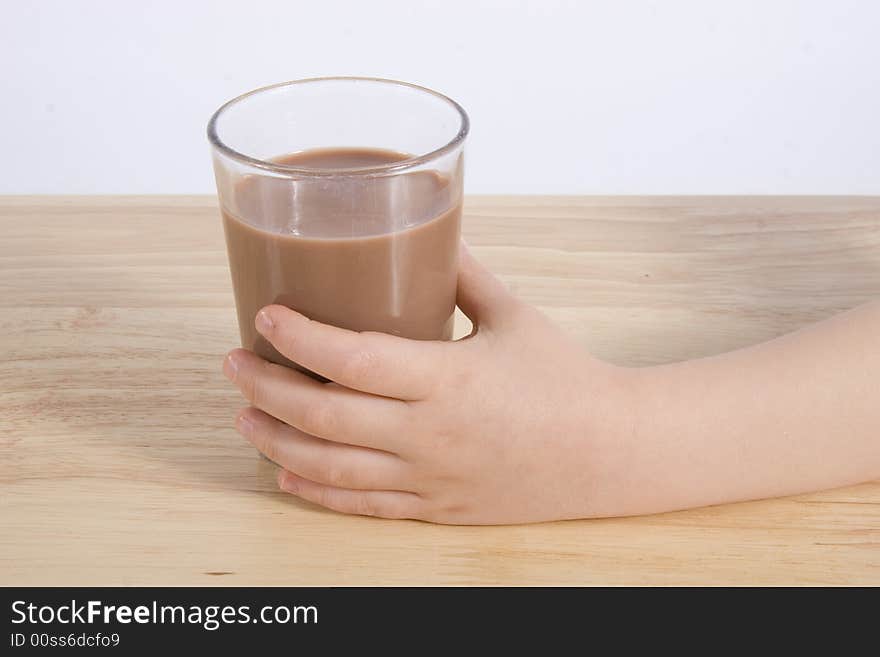 A hand with a glass milk chocolate