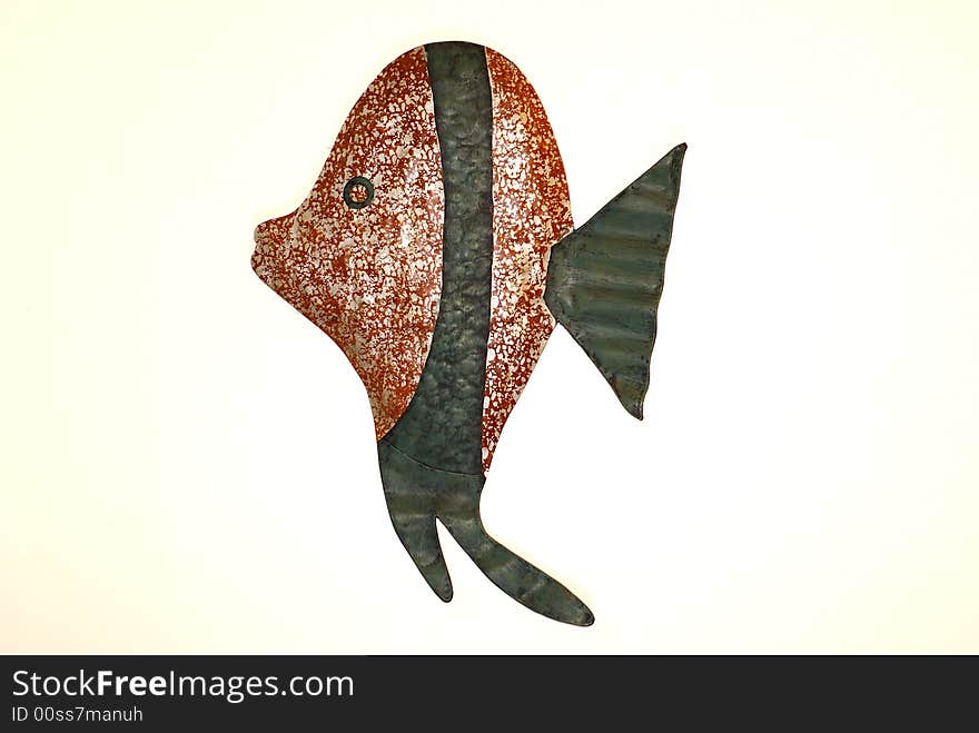 Rust and white and green patterned fish crafted from metal isolated against white background. Rust and white and green patterned fish crafted from metal isolated against white background