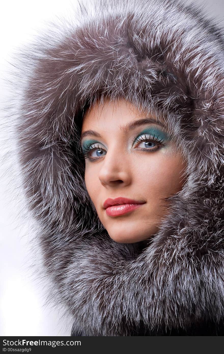 Beautiful young woman with a fur hood