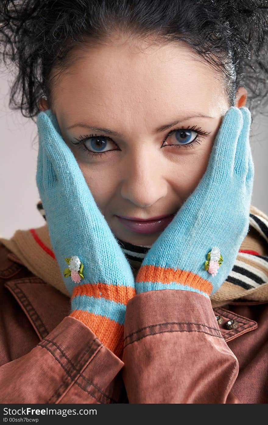 A girl in a striped scarf and blue gloves. A girl in a striped scarf and blue gloves