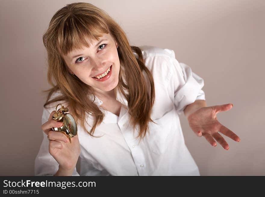 A nice woman in a white shirt holding an alarm-clock. A nice woman in a white shirt holding an alarm-clock