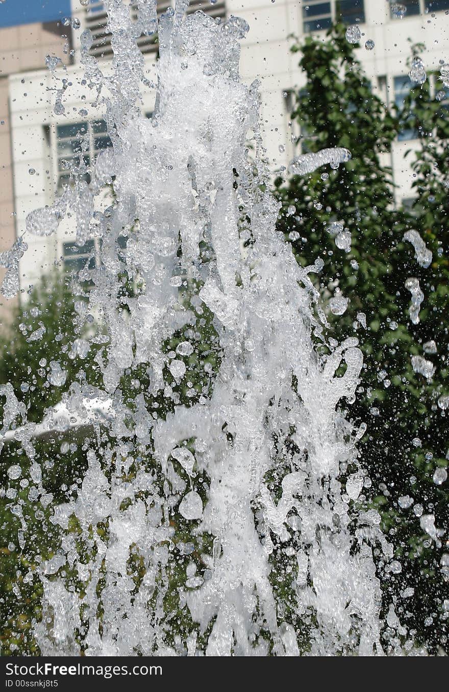 Fragment of fountain water drops in the air, with little bubbles in them.