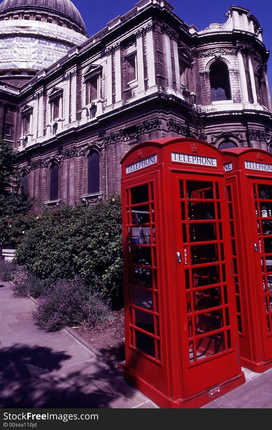 Old red telephones with old building background. Old red telephones with old building background