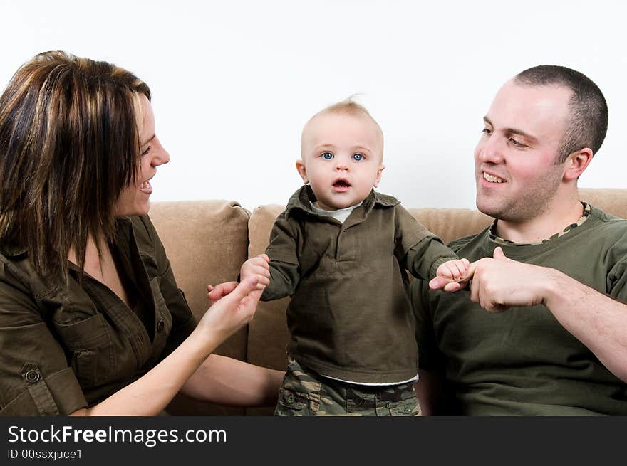 Mom and dad on a sofa with their baby boy. Mom and dad on a sofa with their baby boy