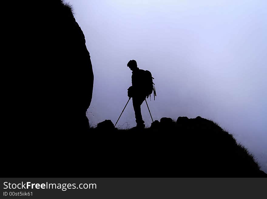 Young man walking in a mountain on a foggy day. Young man walking in a mountain on a foggy day.