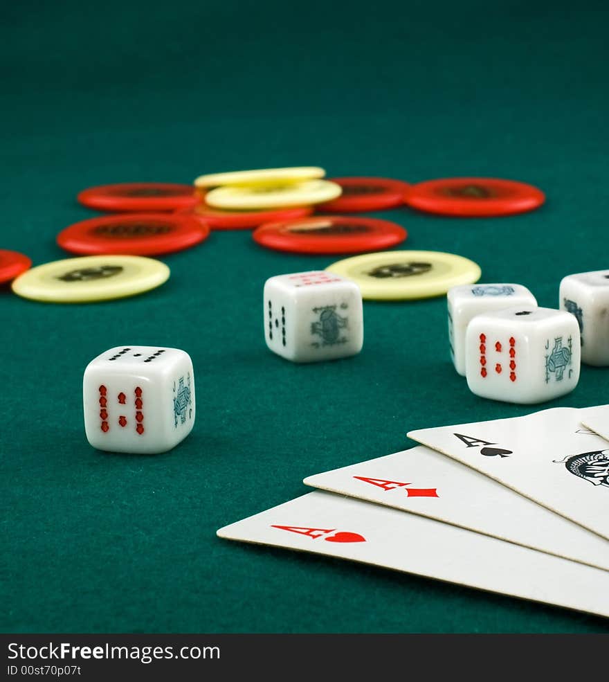 Aces, dice and chips on green carpet with shallow depth of field